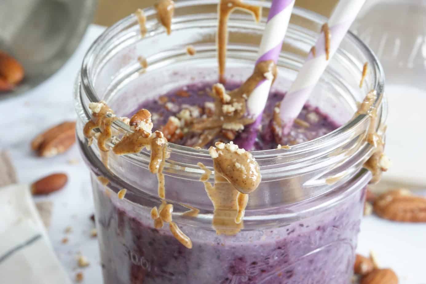 almond butter on a blueberry smoothie glass