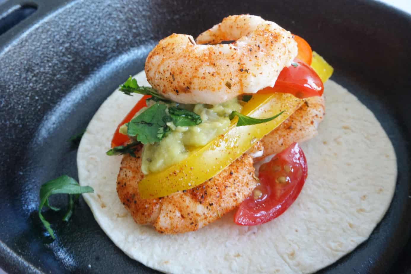 shrimp fajitas with seasoning, guacamole and cilantro on a low carb taco shell