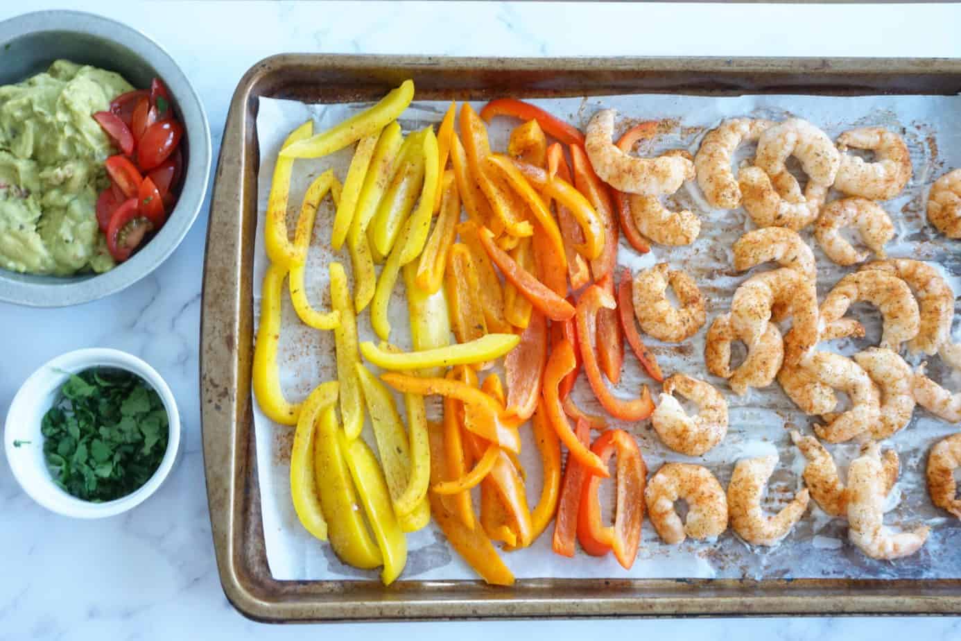 shrimp fajitas with seasoning, guacamole and cilantro