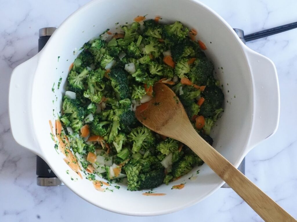 broccoli, carrots and onions with melted butter in a pot