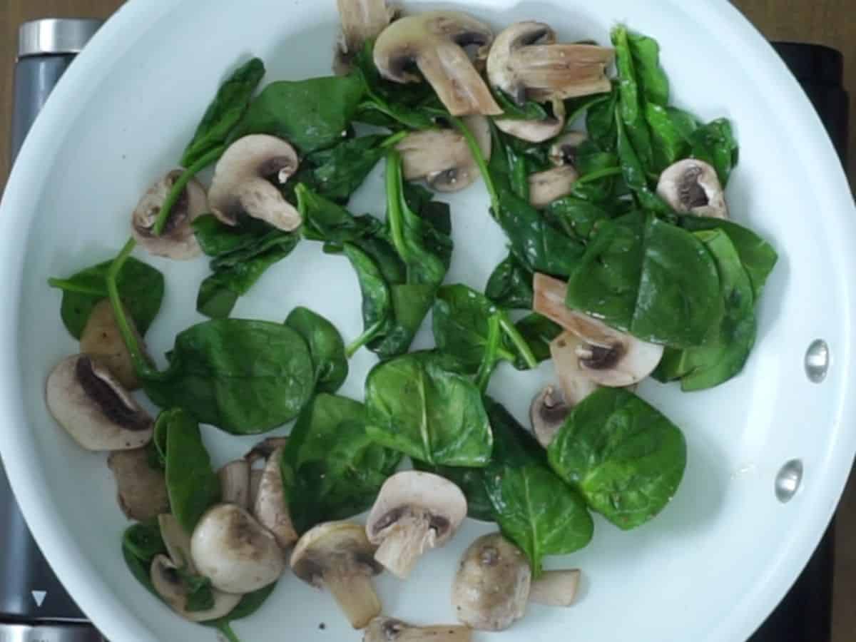 cooked spinach and mushrooms in frying pan