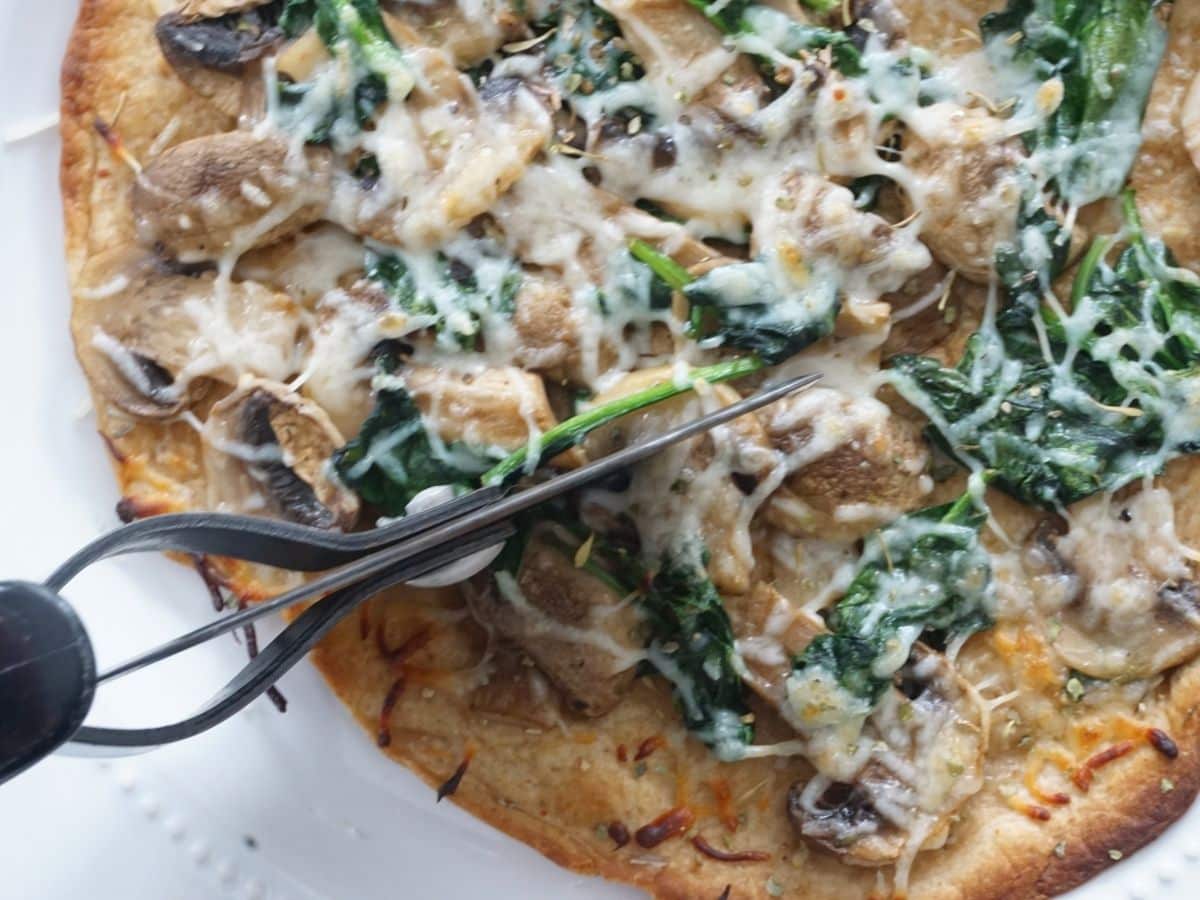 cutting into a spinach mushroom quesadilla