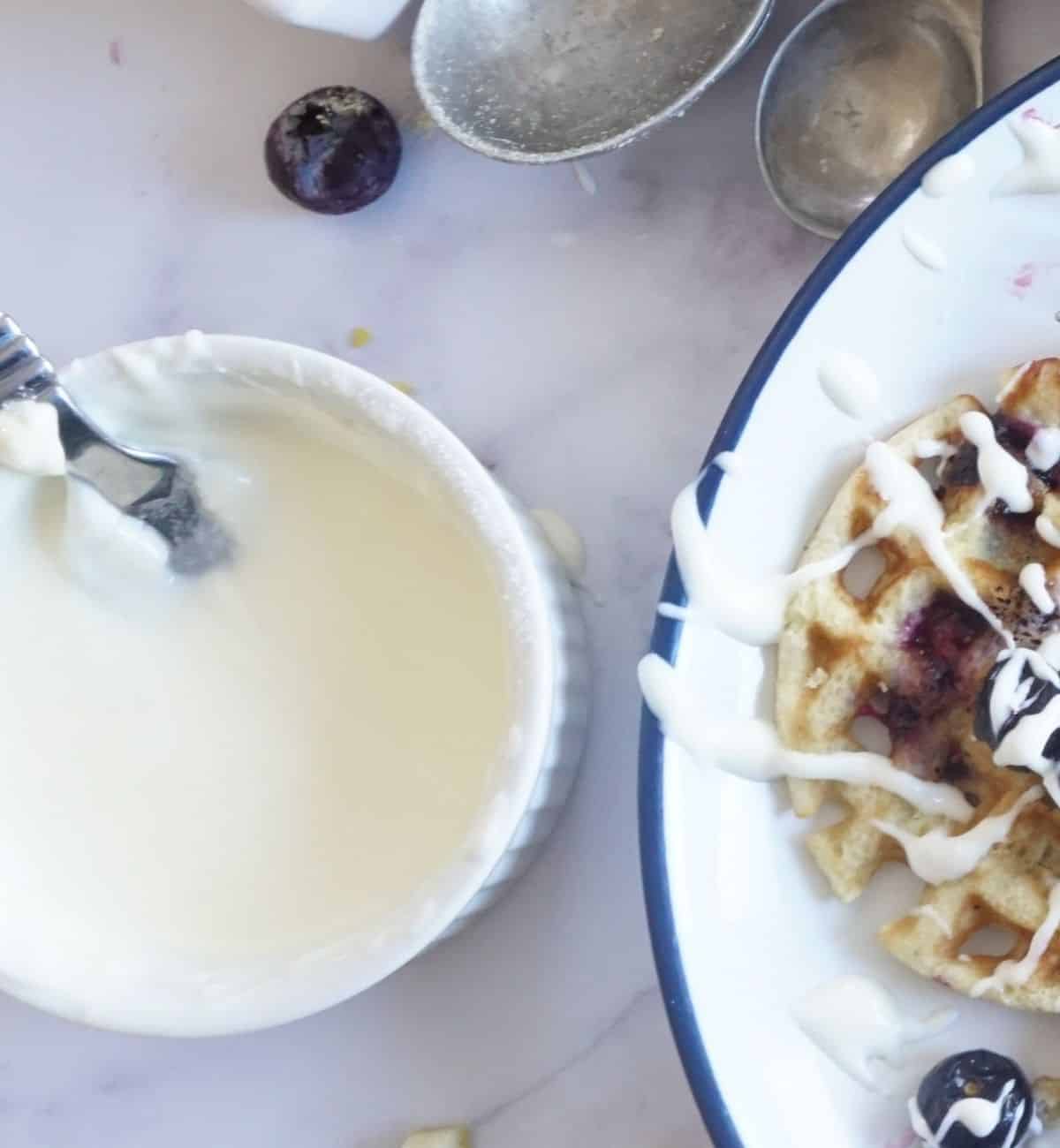 close-up of cream cheese icing on a blueberry waffle