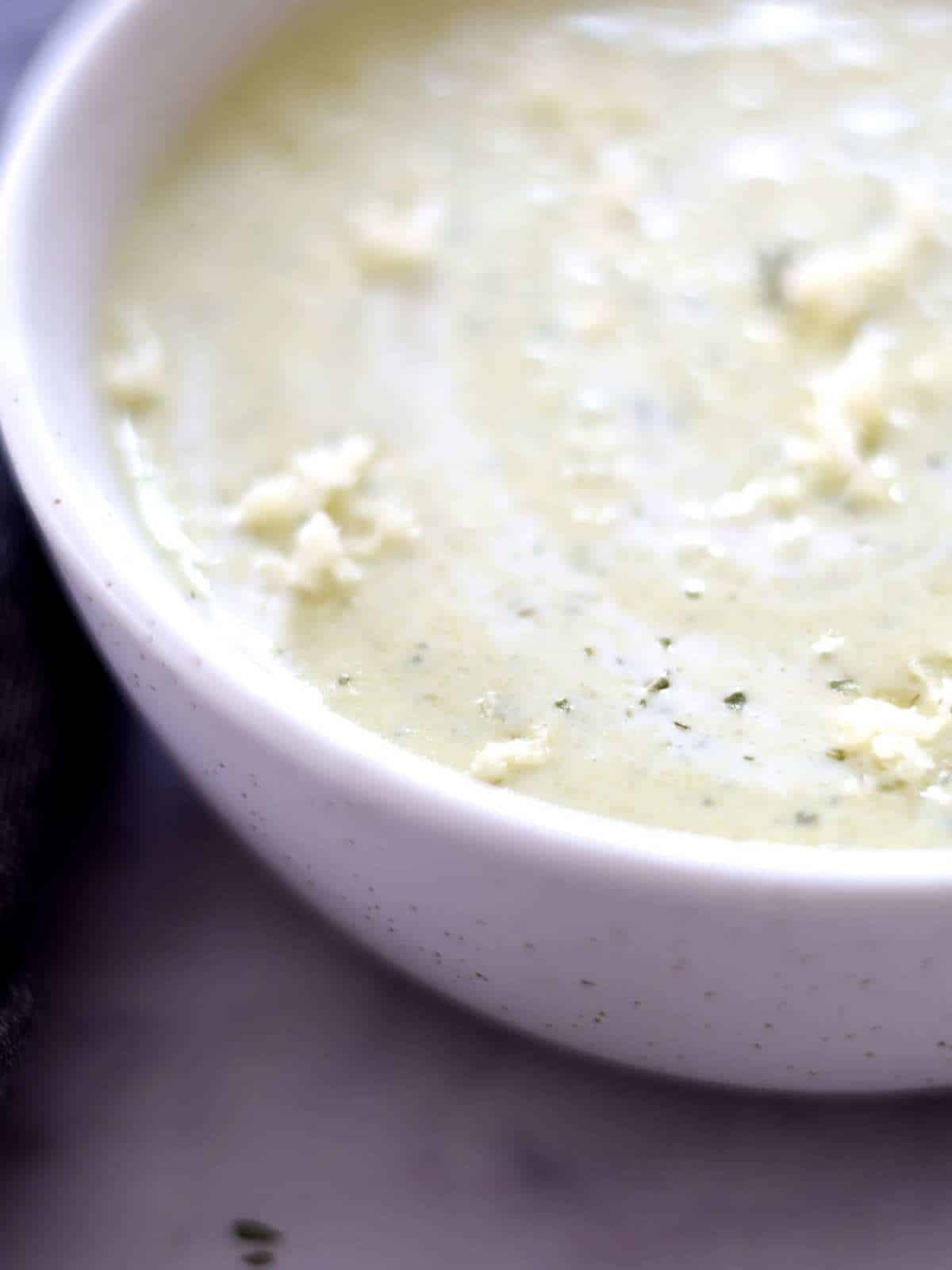 large bowl of poblano cheddar soup with parmesan cheese