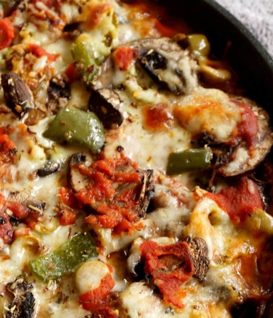 close up of deep dish pizza with green peppers mushrooms cheese