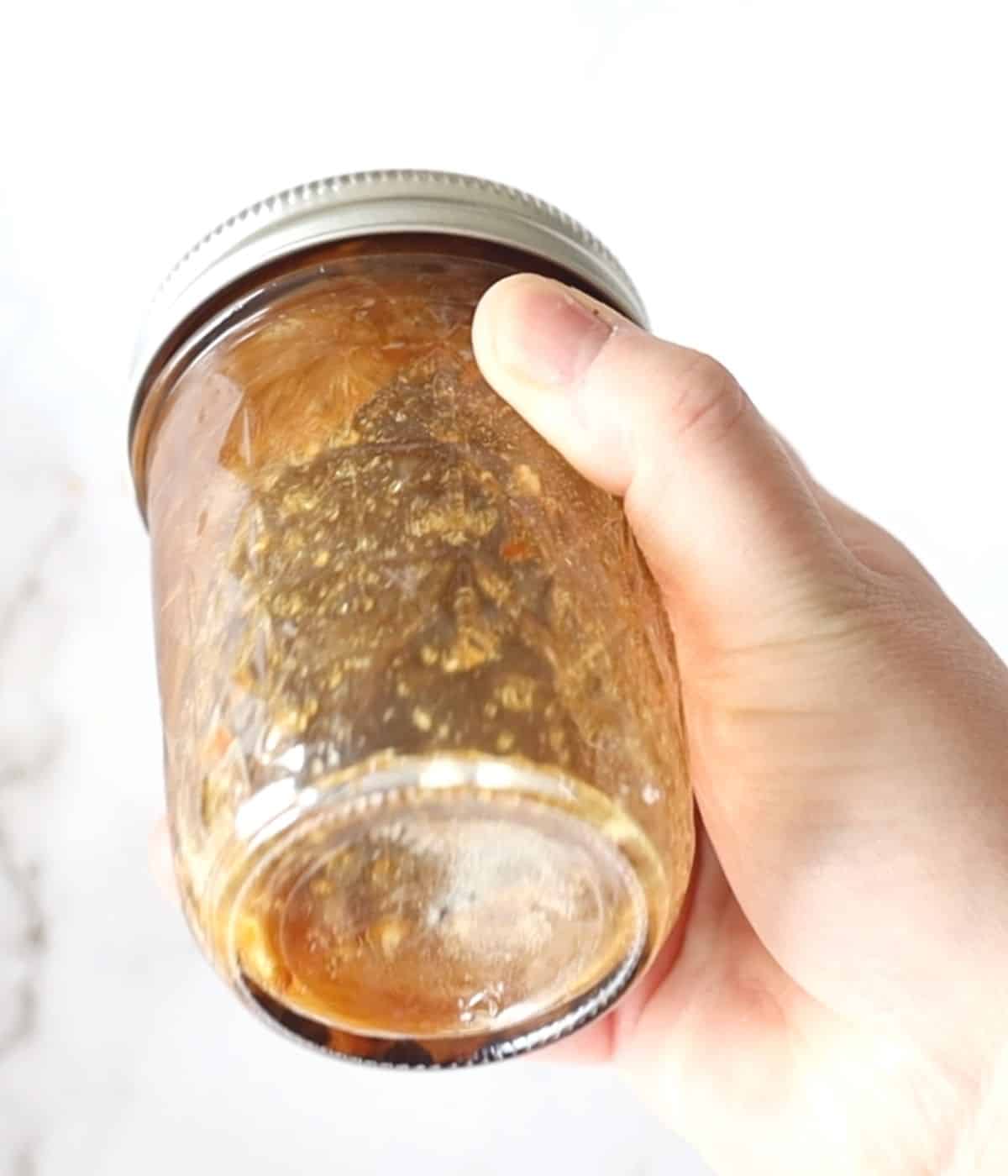 shaking a jar with ingredients for sauce