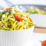 bowl of zoodle pasta with cherry tomatoes, feta cheese and fresh parsley