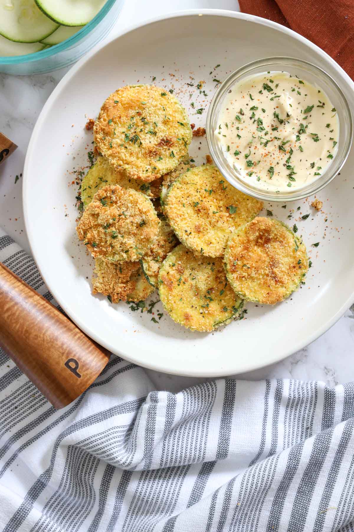 parmesan zucchini crisps with peppercorn grinder and dip