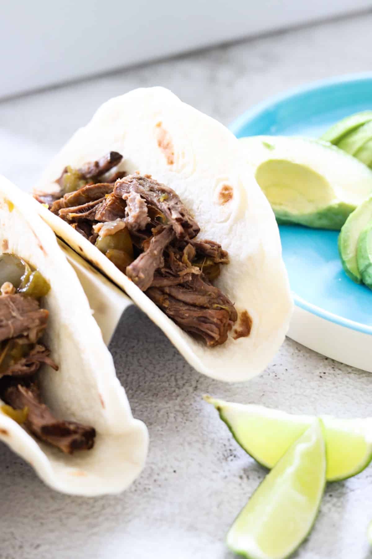 limes and avocado with carne asada