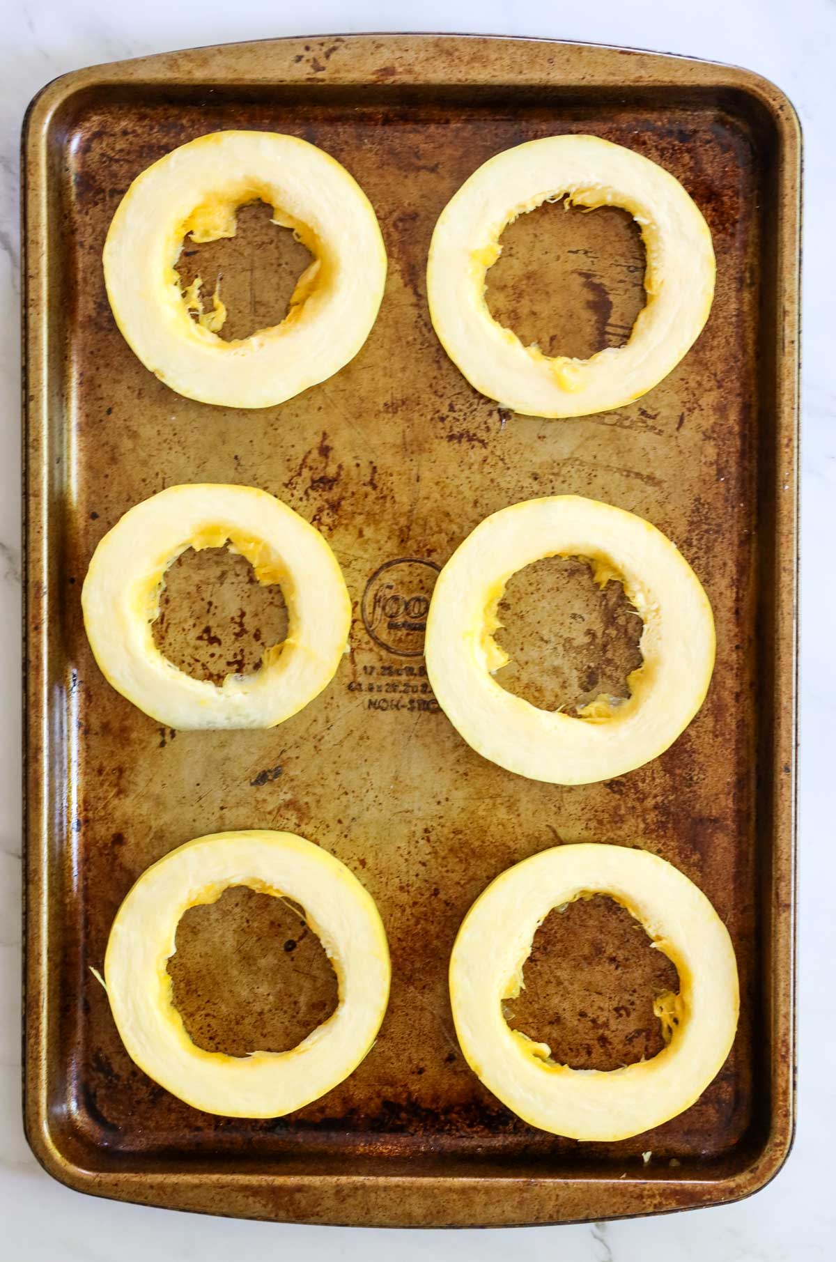 spaghetti squash sliced rings on a large baking pan