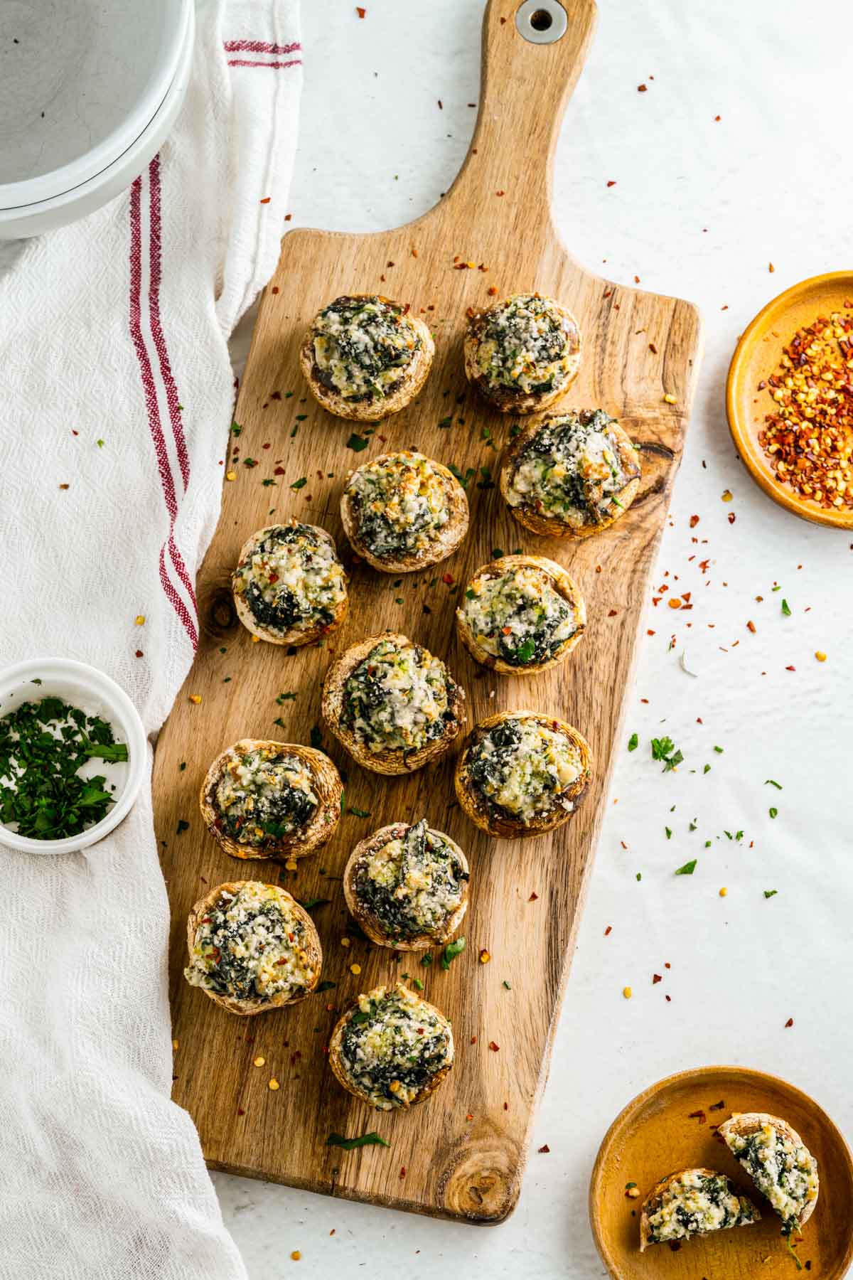 wooden tray with seasonings and a dozen stuffed mushrooms