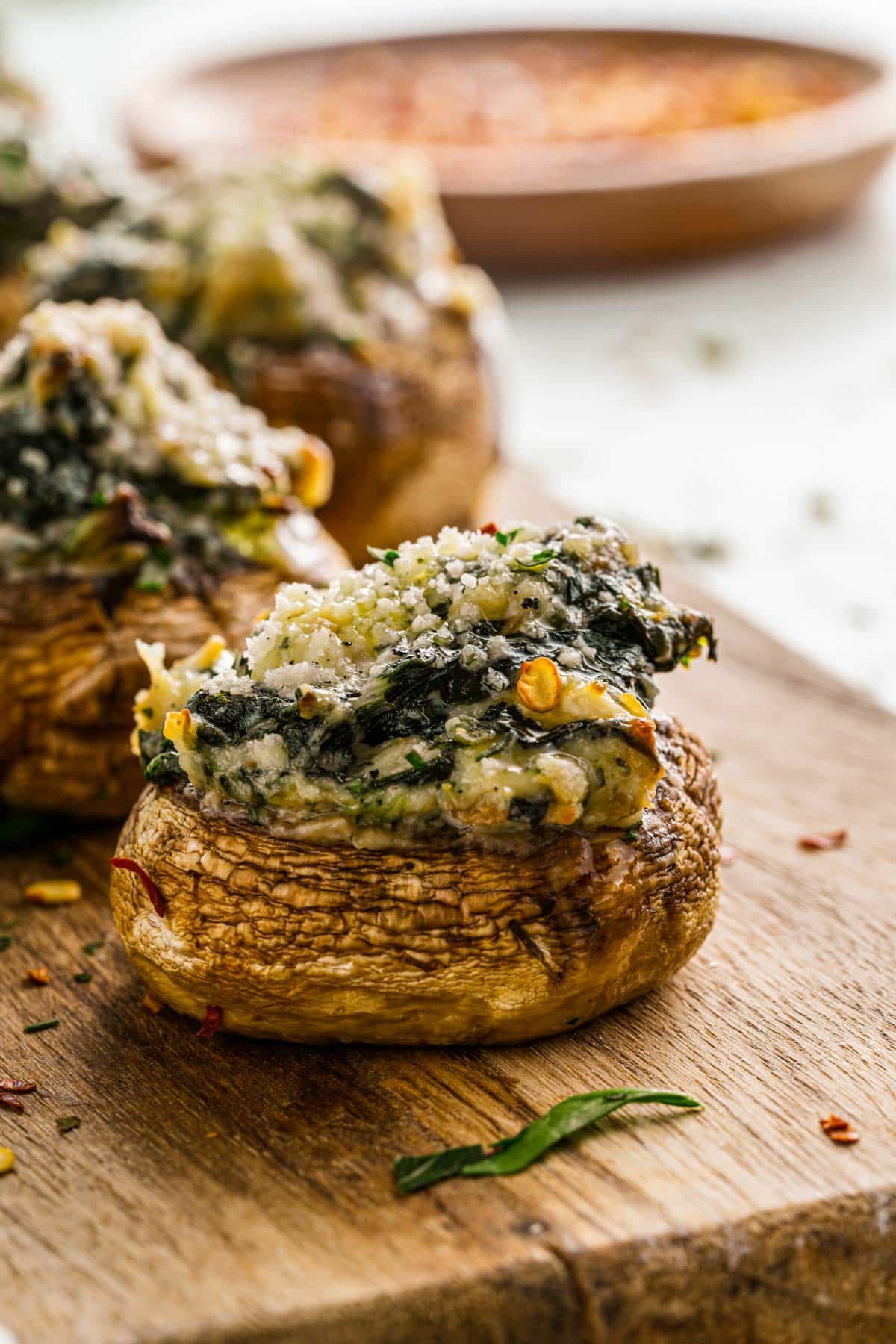 baked mushroom cap with creamy cheese on a wooden chopping block