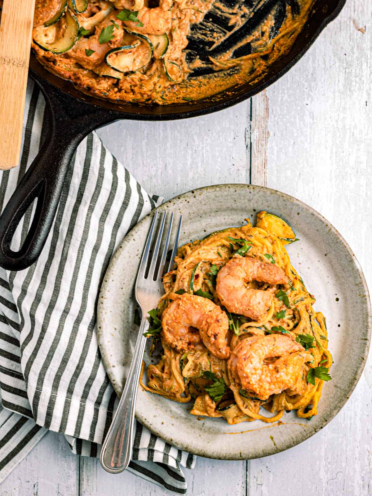 pan with creamy zucchini topped with Mediterranean shrimp