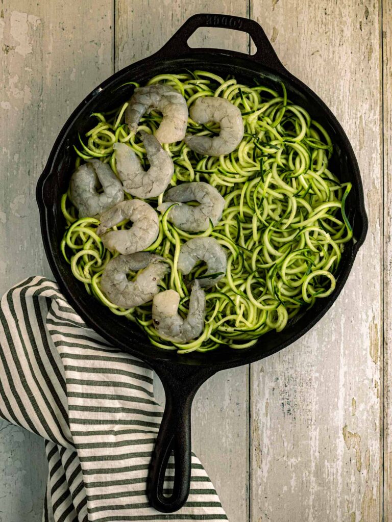 adding shrimp and zucchini spirals to pan