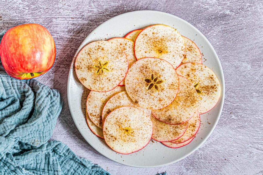 thin apple slices with cinnamon on a plate