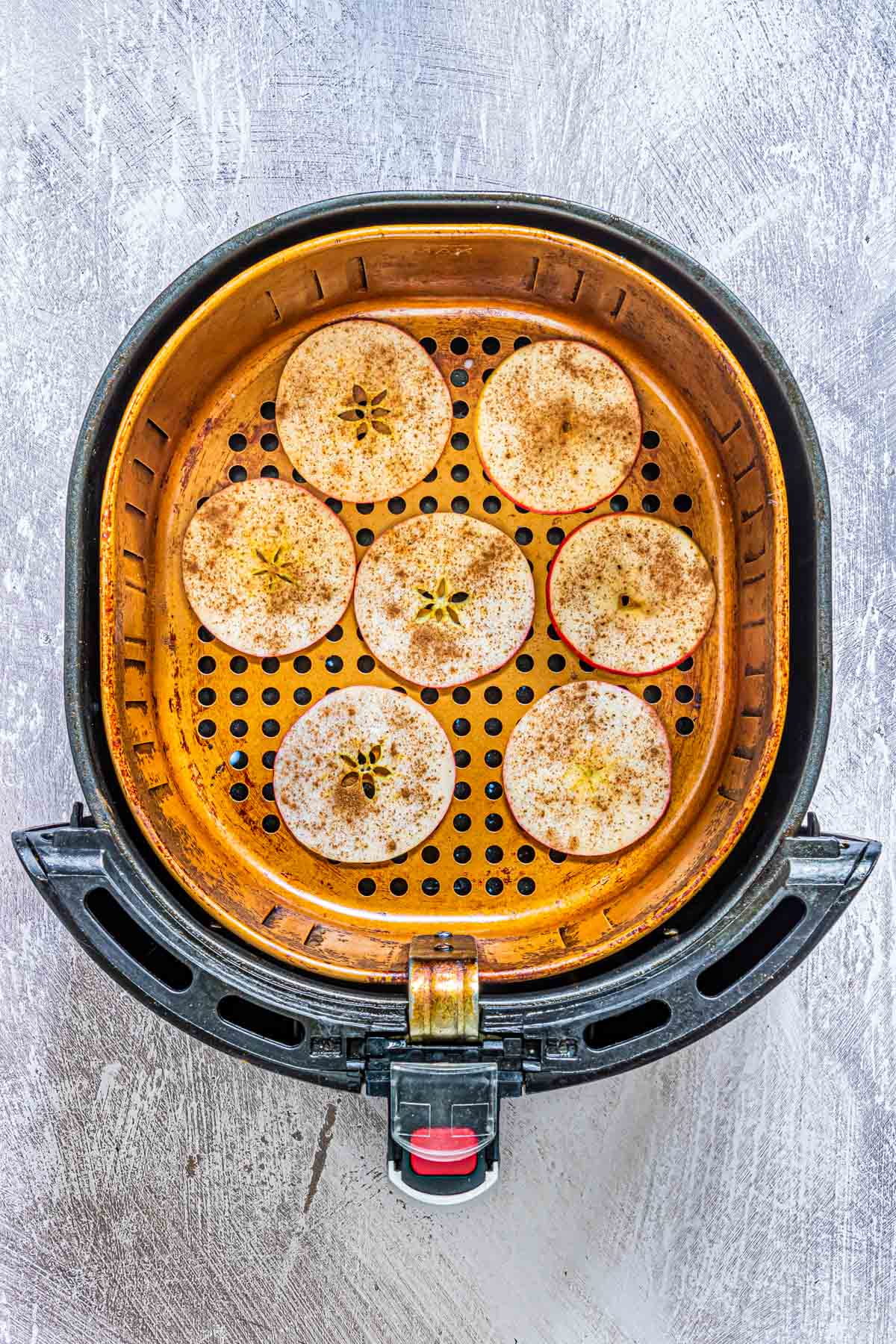 apple slices added to an air fryer basket