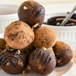 stack of round truffles with chocolate sauce in the background