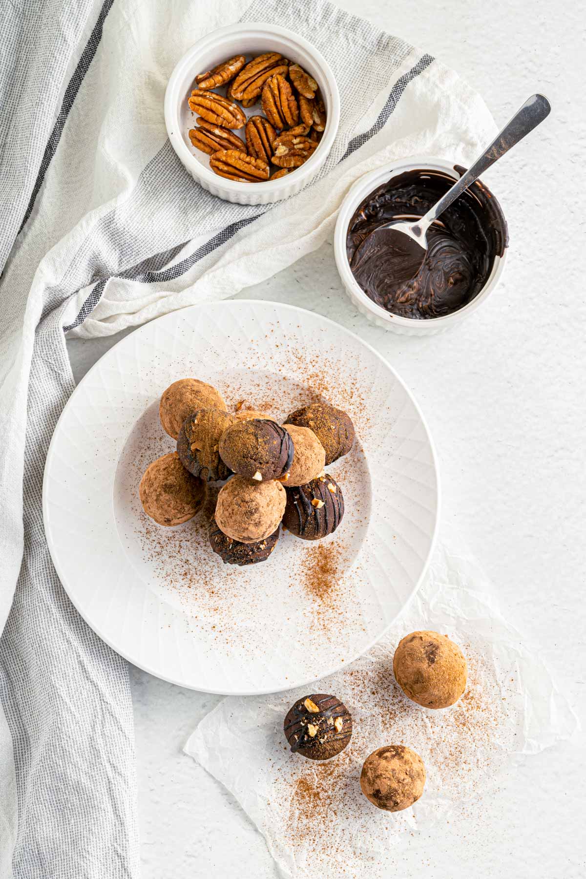 preparing truffles with chocolate drizzle and cocoa powder