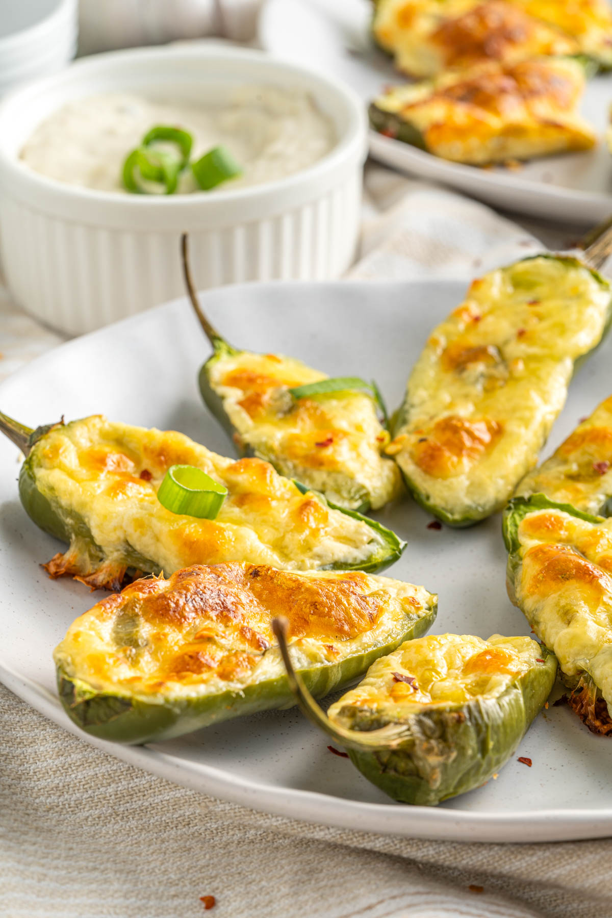 golden cheesy jalapeño poppers arranged on a plate with ranch dressing