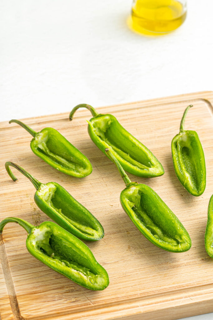sliced jalapeño peppers without seeds on a wooden cutting board