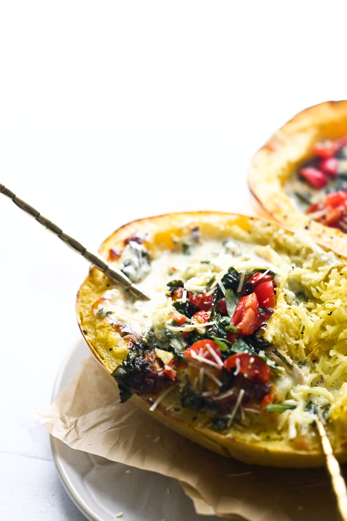 diced cherry tomatoes and spinach in a creamy baked spaghetti squash