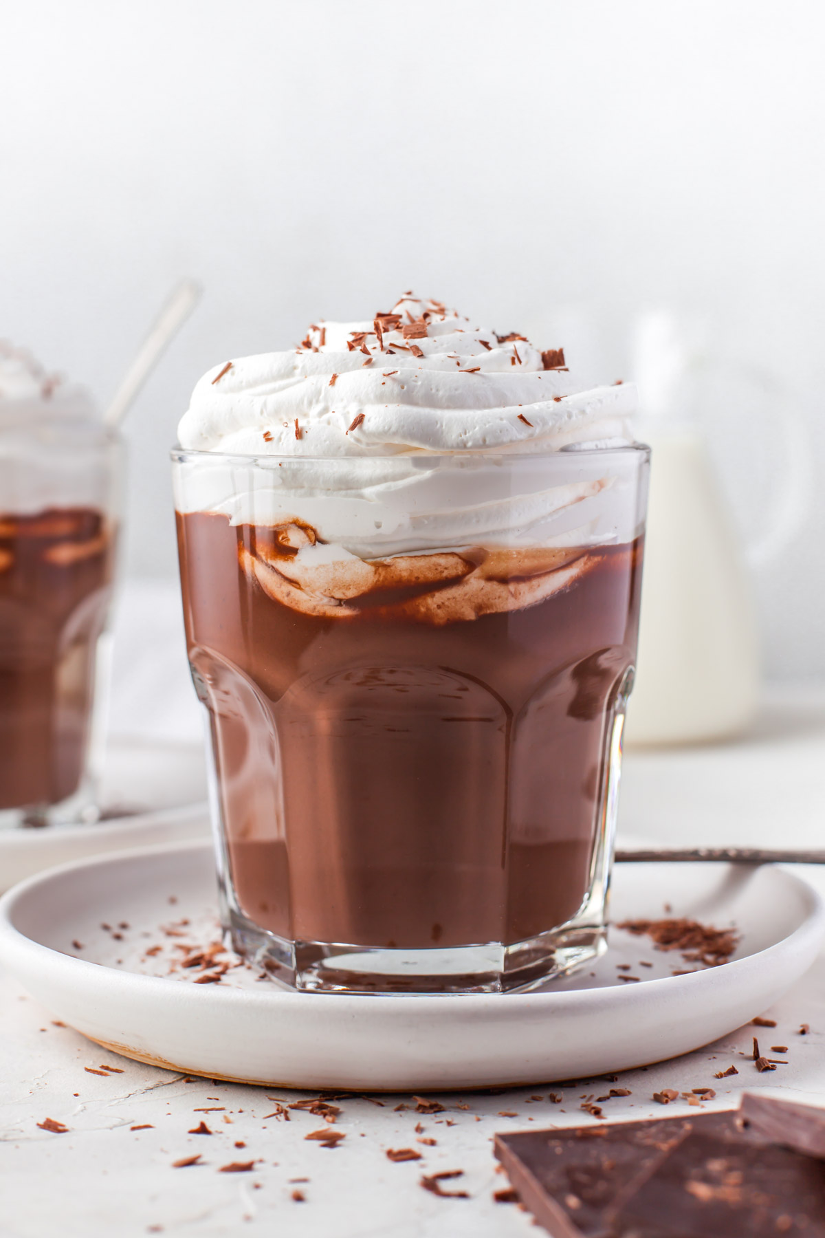 side view of cup with thick hot chocolate topped with lots of heavy whipping cream
