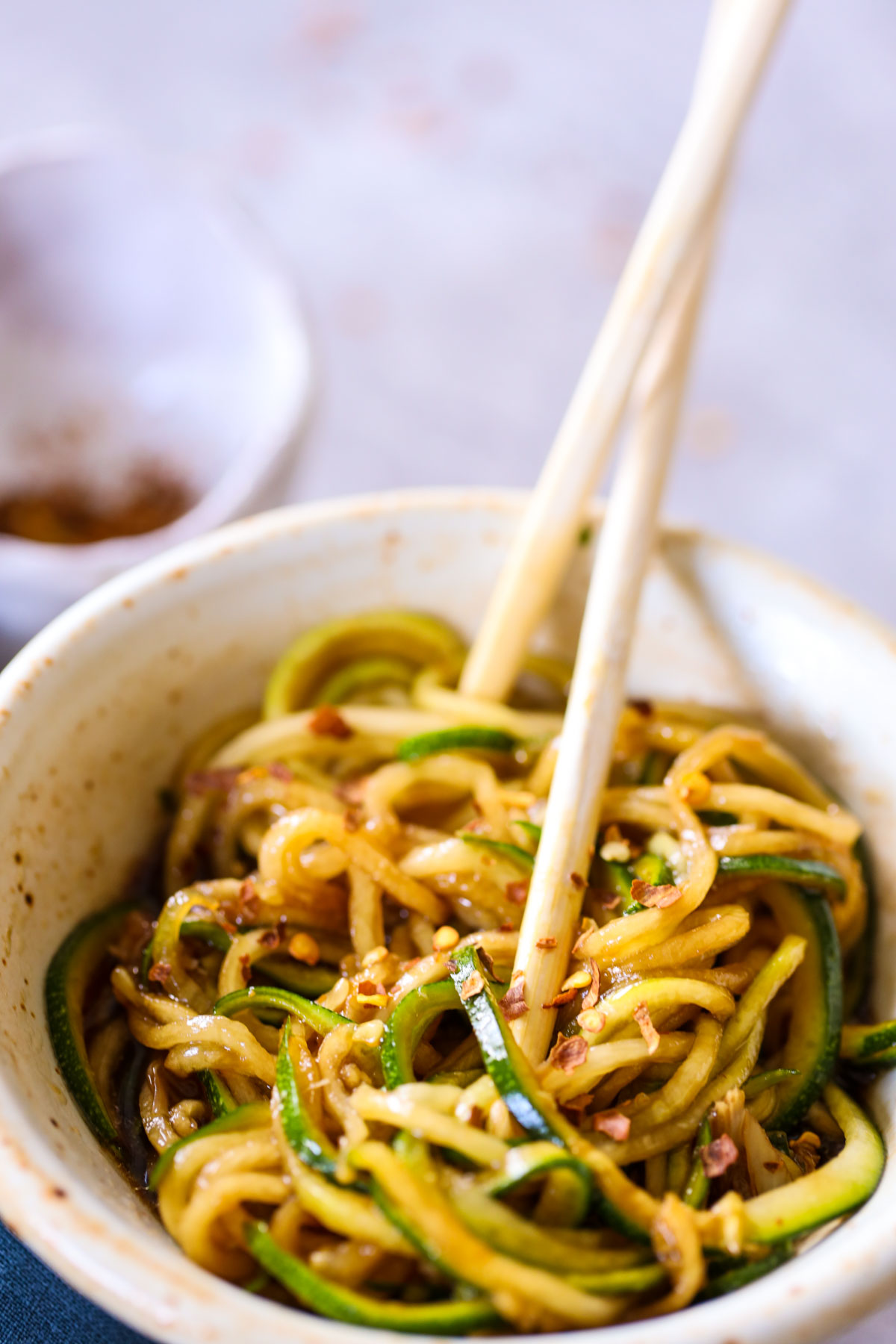 chopsticks in a bowl of zoodle lo mein