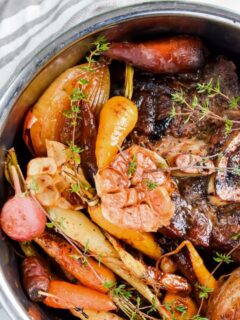 Instant Pot with beef, garlic, herbs, onion, carrots and radishes