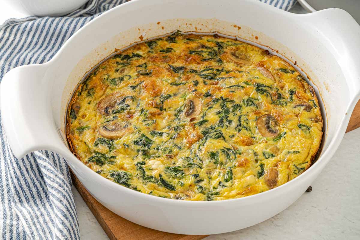 round white casserole dish with a spinach mushroom frittata