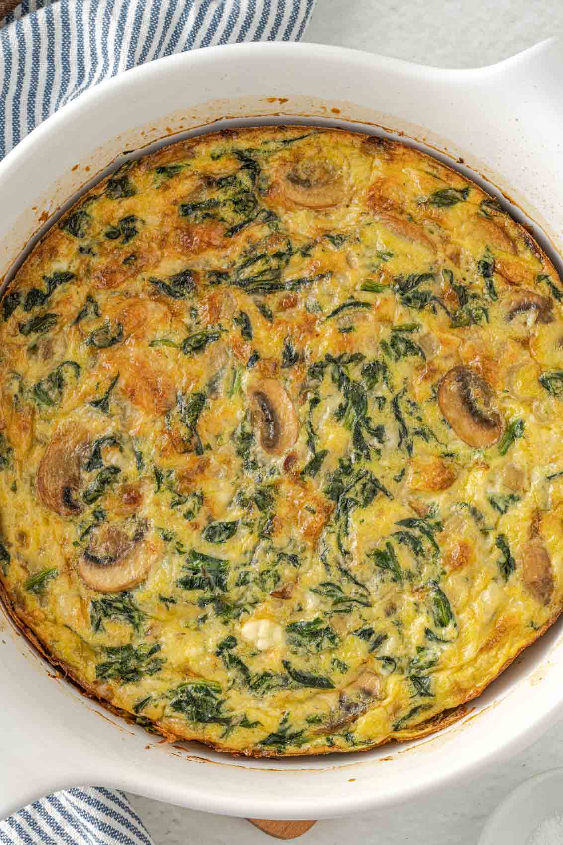 overhead view of a spinach mushroom frittata with a golden cheesy crust