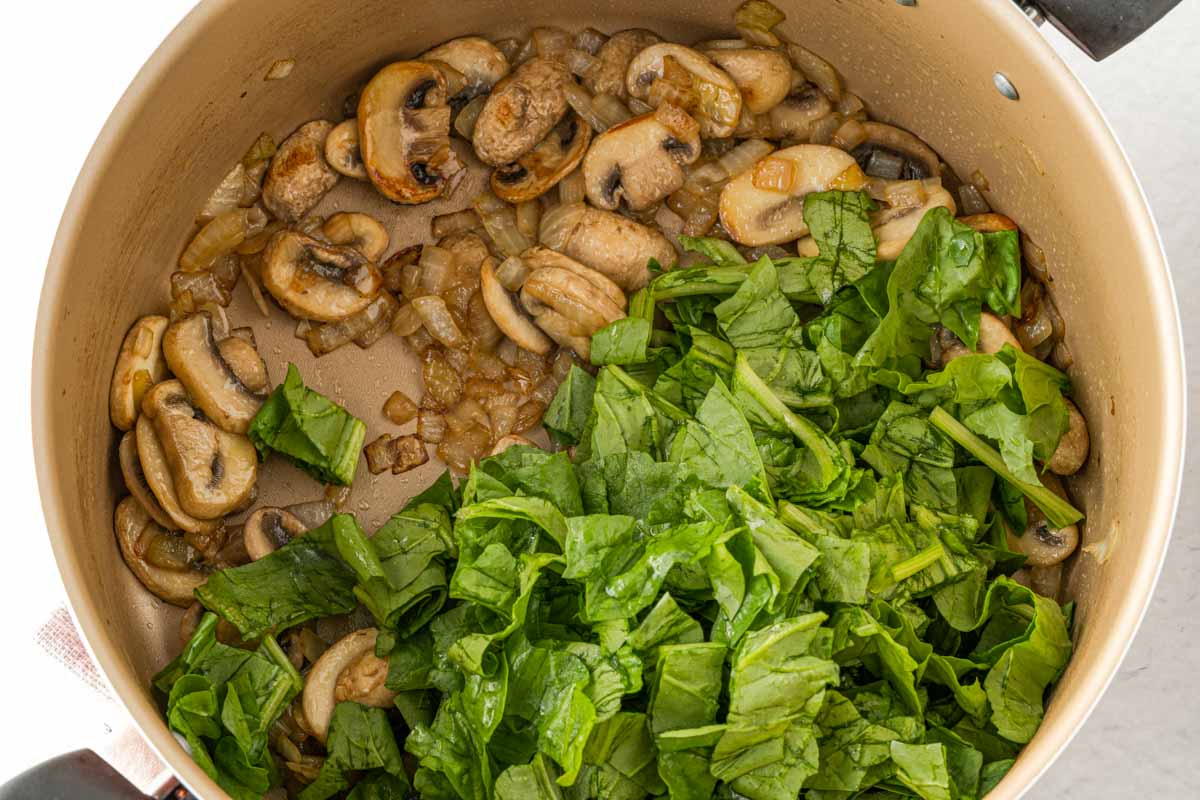 sautéing mushrooms and spinach in a frying pan