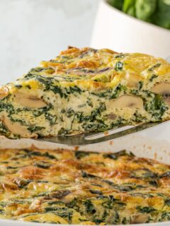 spatula lifting a frittata with spinach and mushrooms