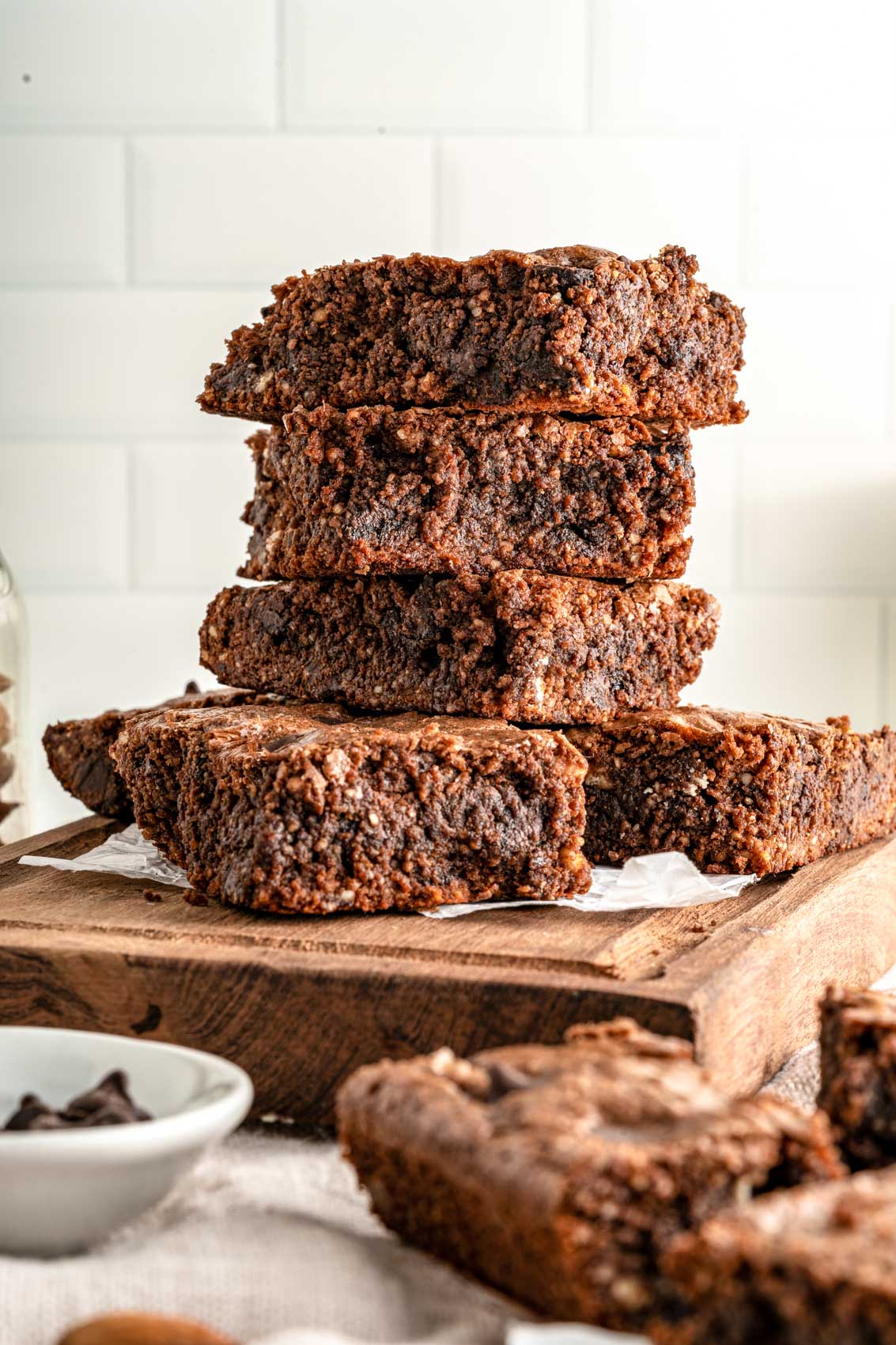 stacked brownies on a cutting board with parchment paper