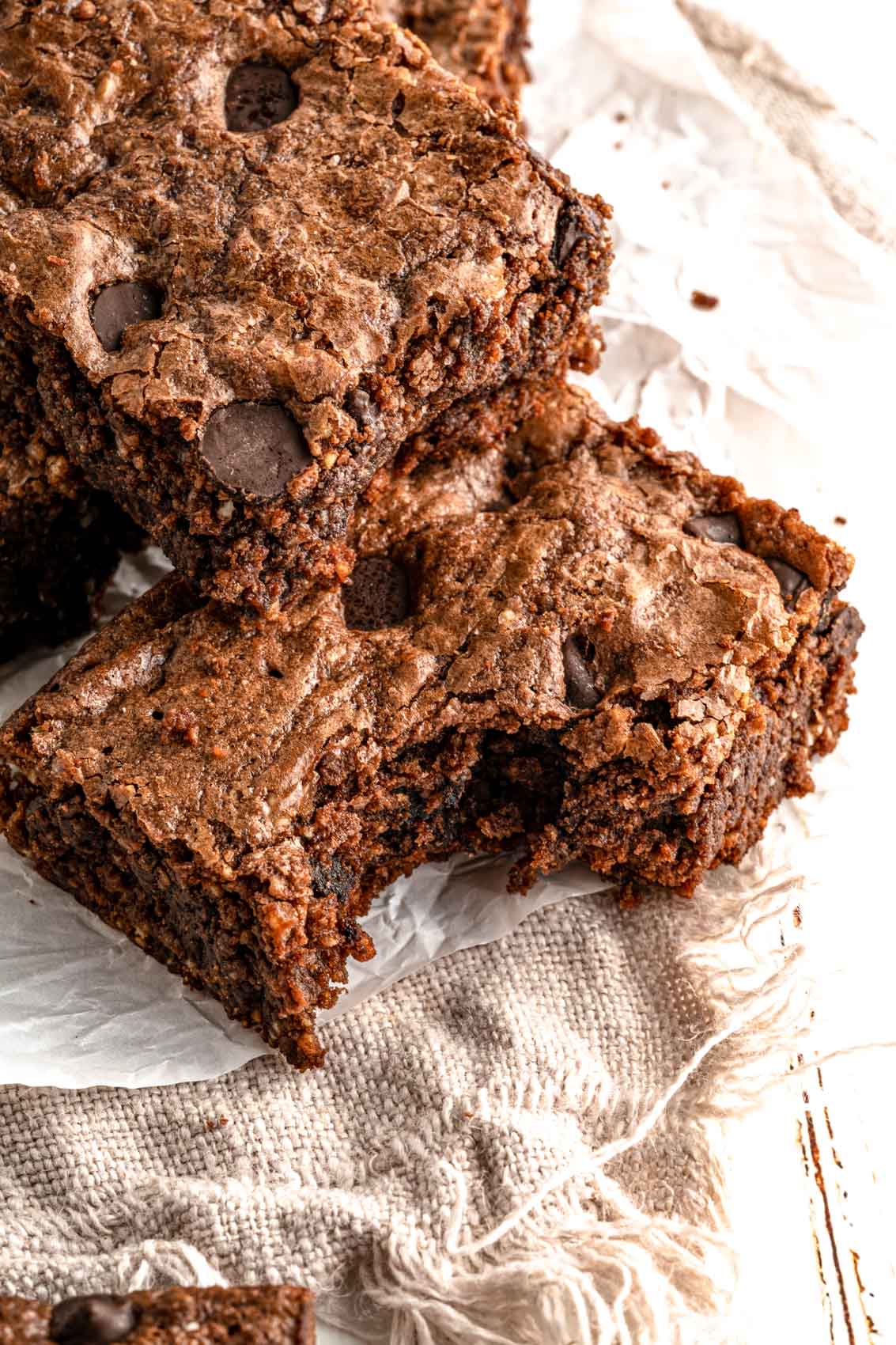 thick brownies stacked on top of one another with a bite taken out of one