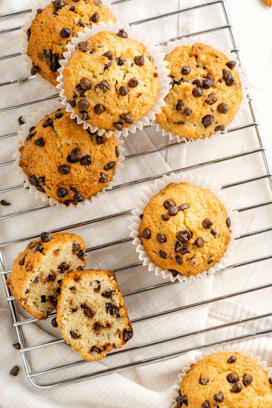 chocolate chip muffins on a cooling rack with a linen