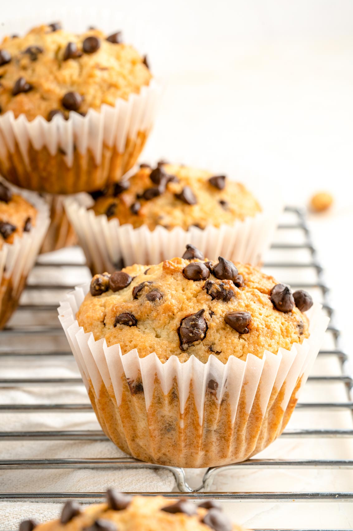 stack of chocolate chip muffins on a cooling rack