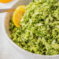 green goddess salad in a bowl with lemon wedges