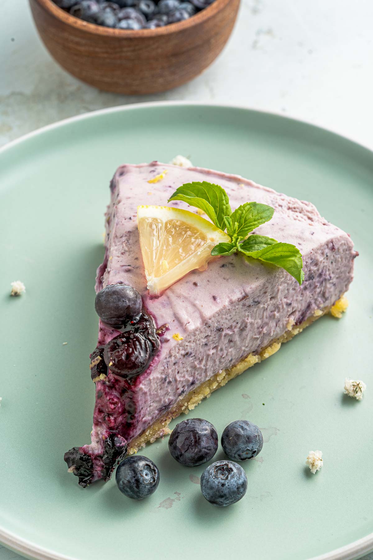 bowl of blueberries next to cheesecake