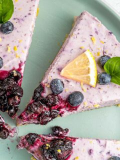 slice of blueberry cheesecake with a lemon wedge and garnish