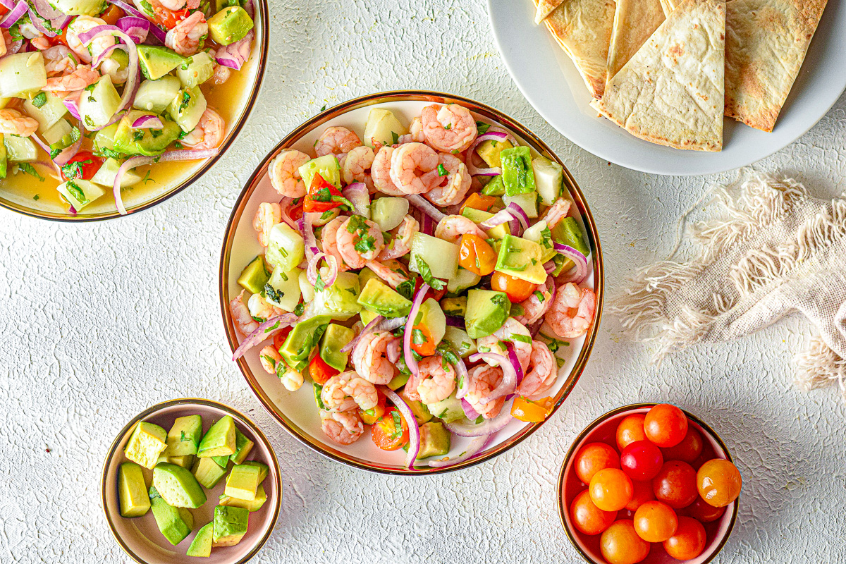 bowl of avocados, tortillas and chips next to shrimp ceviche and linen