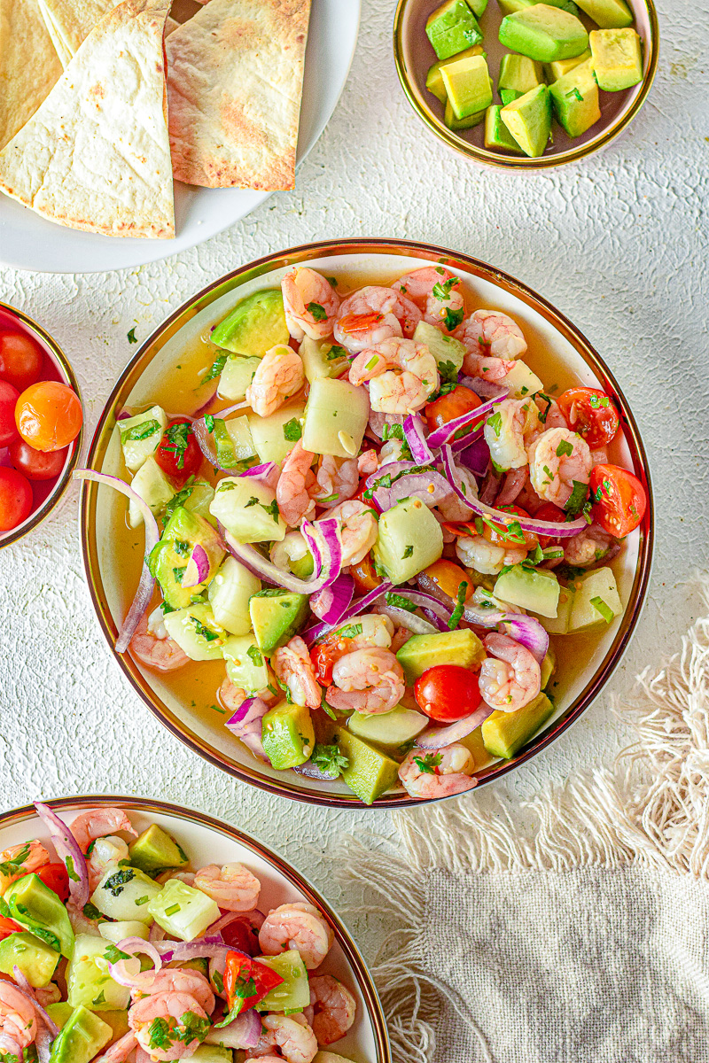 shrimp ceviche in a bowl with red onion, avocado and cilantro