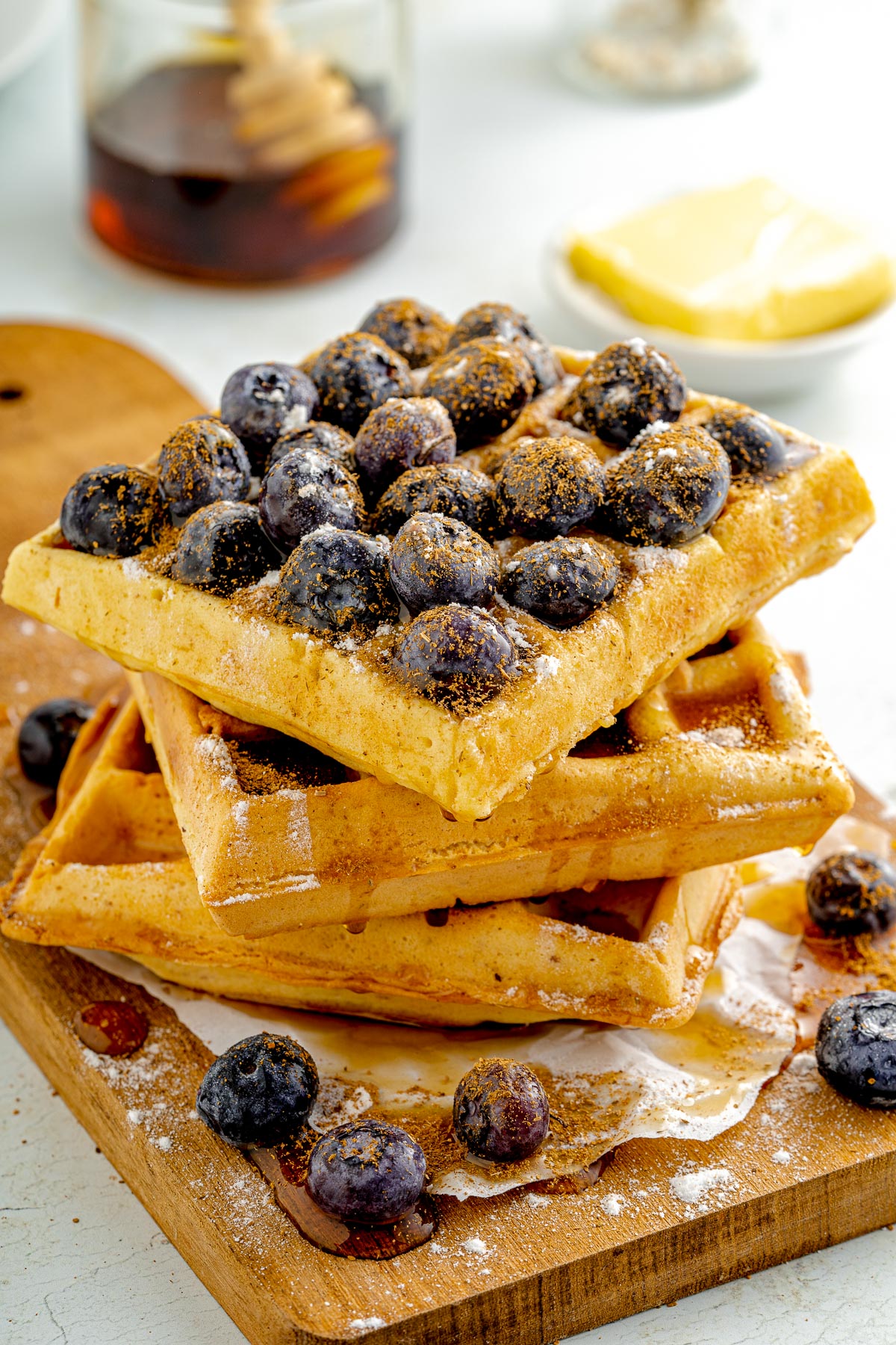 stack of healthy gluten free waffles with blueberries and syrup on top